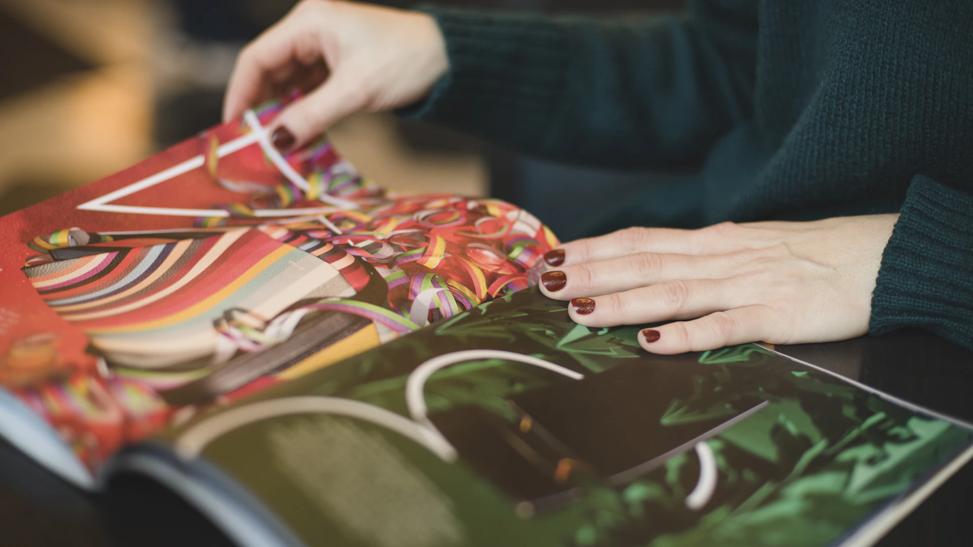 Hände blättern in einem aufgeschlagenen gedruckten Magazin